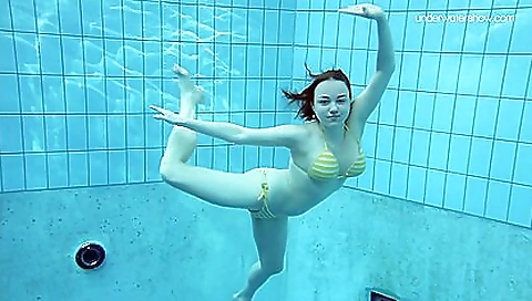 Brunette in swimsuit and towel is swimming in the sea
