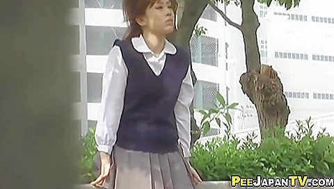 Asian schoolgirl in sexy white bikini pissing in park